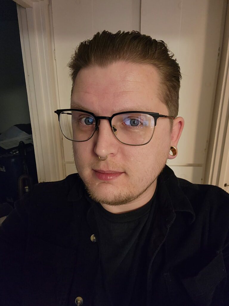 A man with glasses and a black shirt